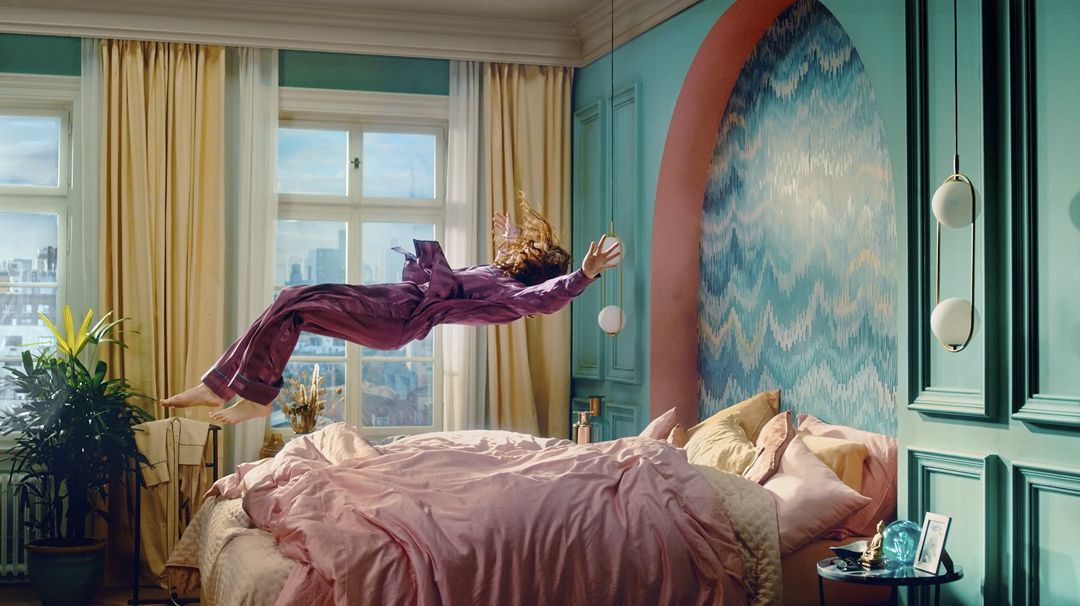 Person fällt auf ein Bett